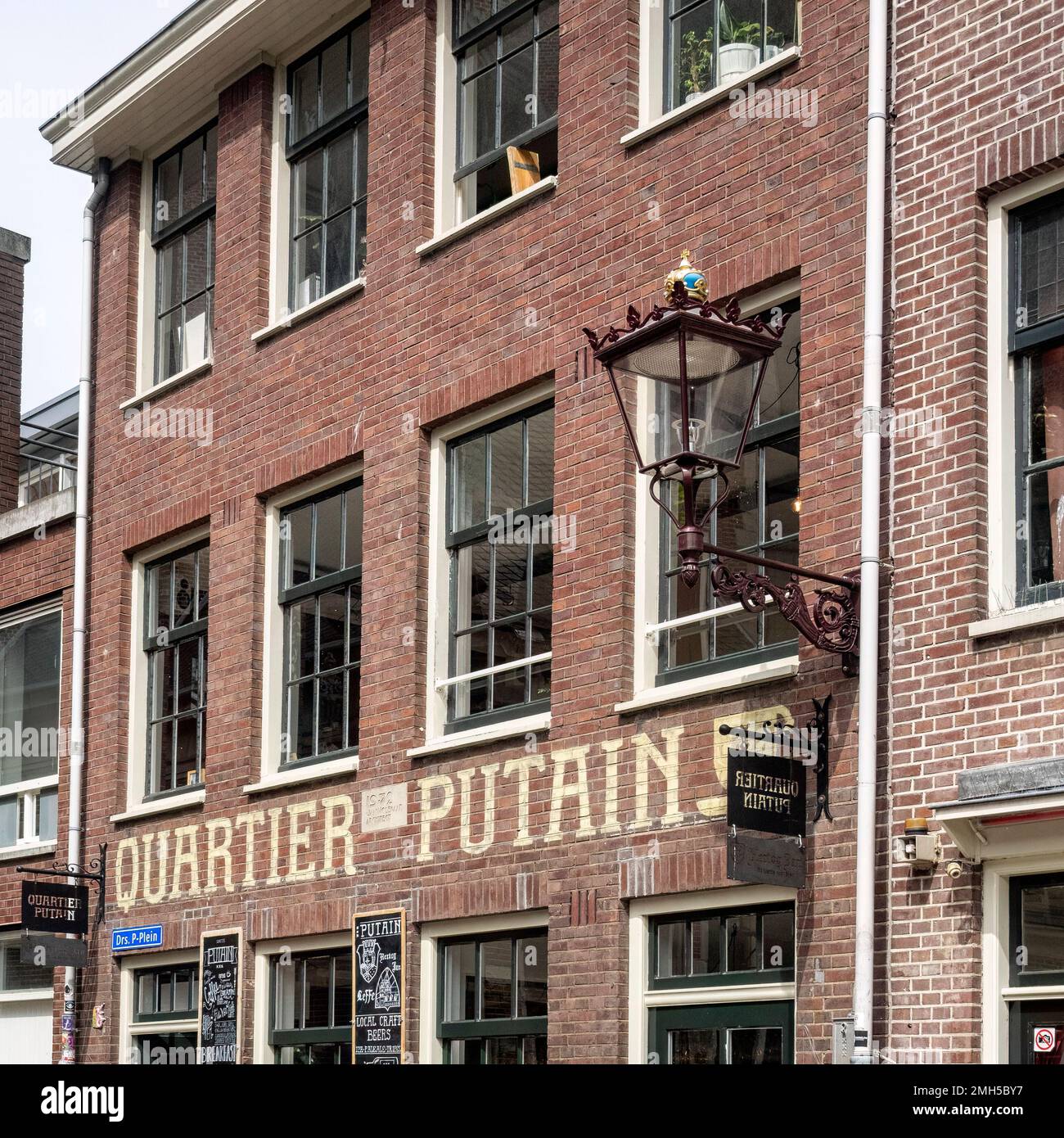 AMSTERDAM, NETHERLANDS - MAY 01, 2018:  Ornate lamp and sign for Quartier Putain restaurant  on  Oudekerksplein street Stock Photo