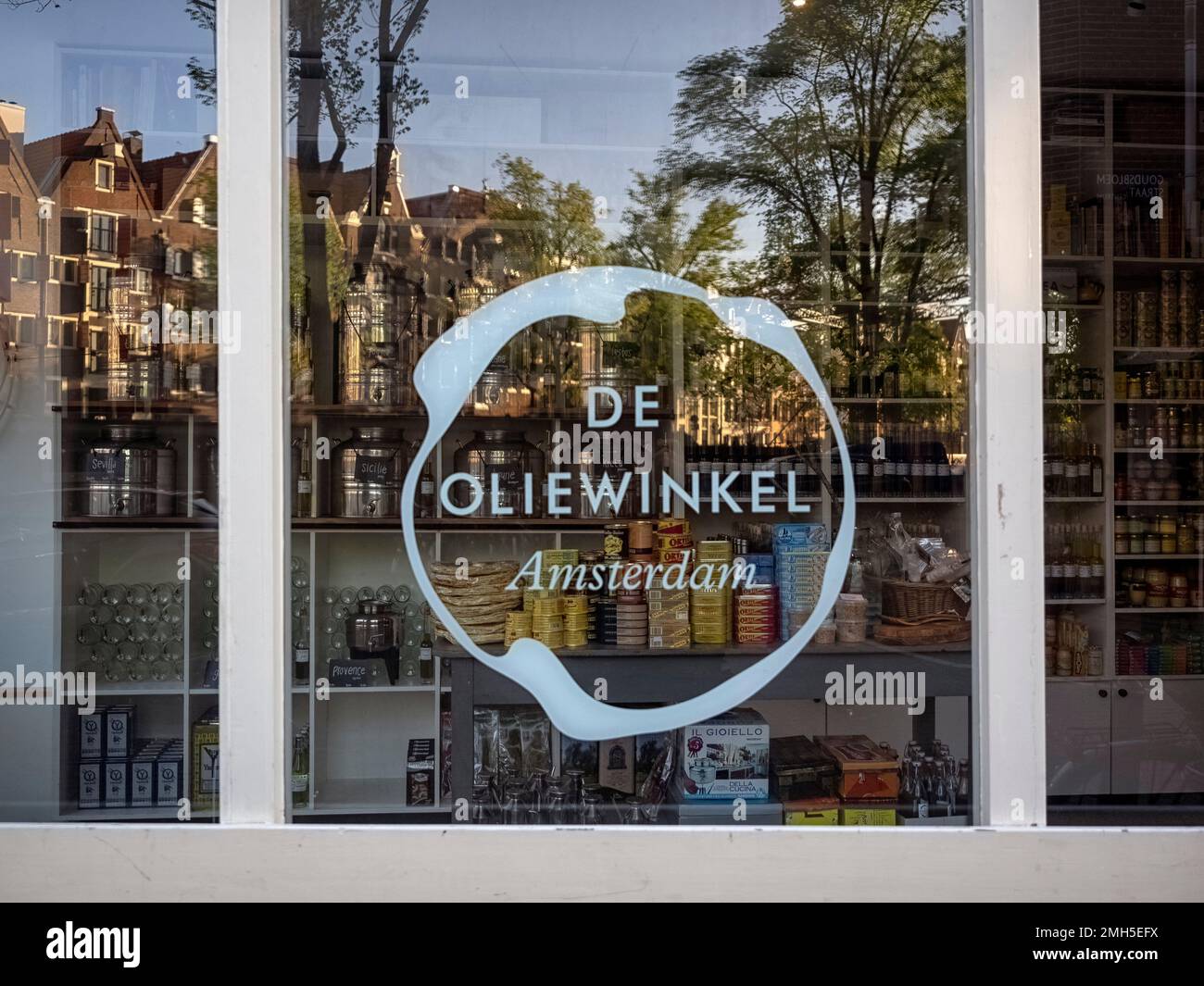 AMSTERDAM, NETHERLANDS - MAY 01, 2018:  View of window of De Oliewinkel Olive Oil shop on Brouwersgracht with sign and  reflections of traditional bui Stock Photo