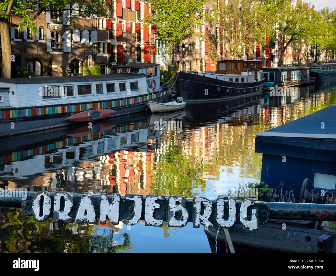 AMSTERDAM, NETHERLANDS - MAY 01, 2018:   Metal sign on the Oranjebrug bridge across the Brouwersgracht canal with a defocused view of boats on the can Stock Photo