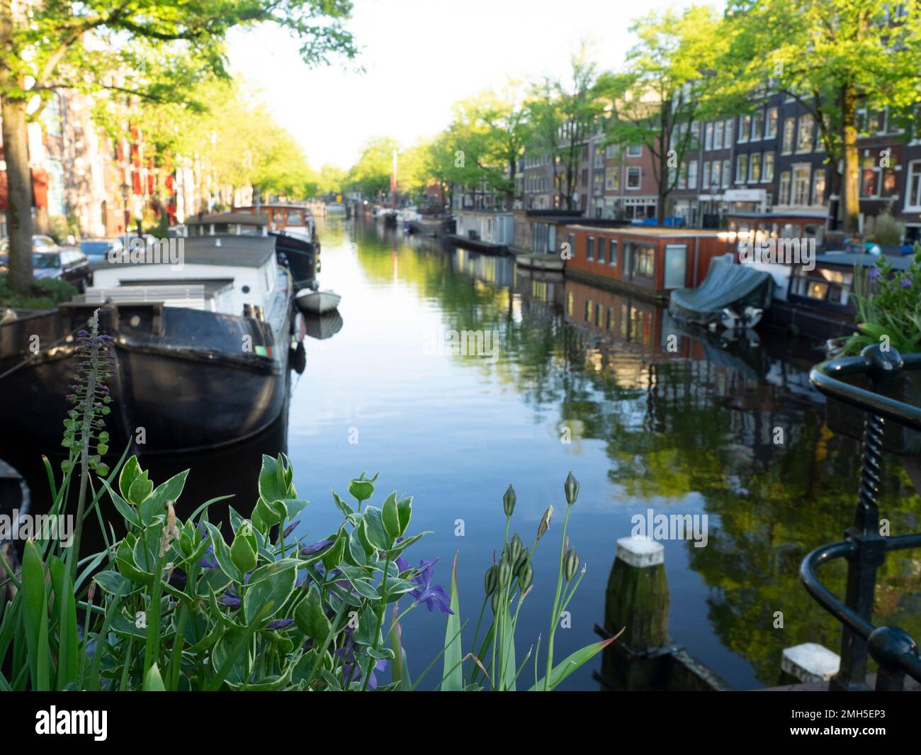AMSTERDAM, NETHERLANDS - MAY 01, 2018:  View along across the Brouwersgracht canal with a defocused view of boats on the canal Stock Photo