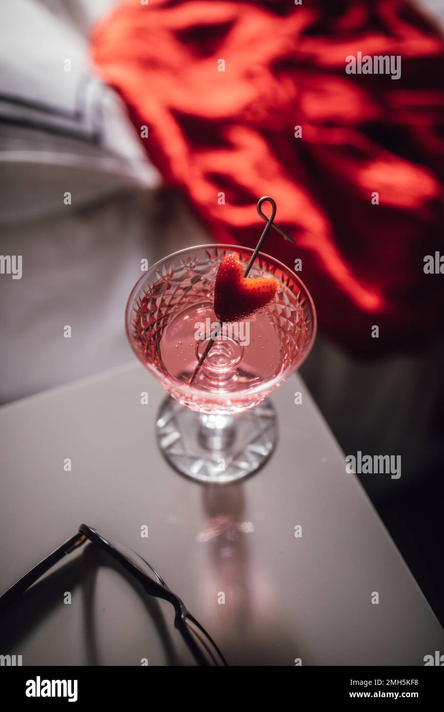 pink sparkling wine drink with strawberry heart garnish on cocktail