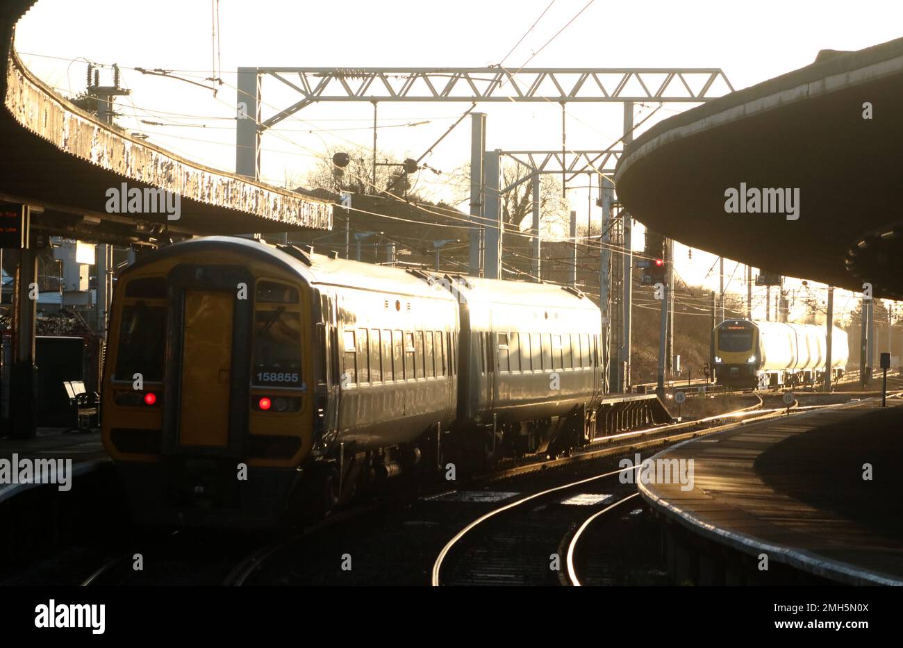 Northern trains express sprinter dmu waiting in Carnforth railway station, 25th January 2023, while Civity dmu passes on West Coast Main Line. Stock Photo