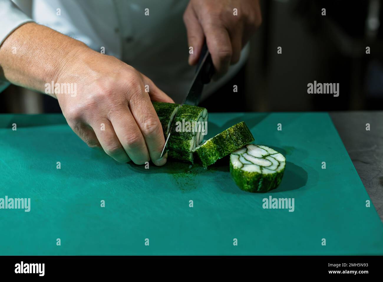 Chopping the fish wrapped in a roll with cling film Stock Photo