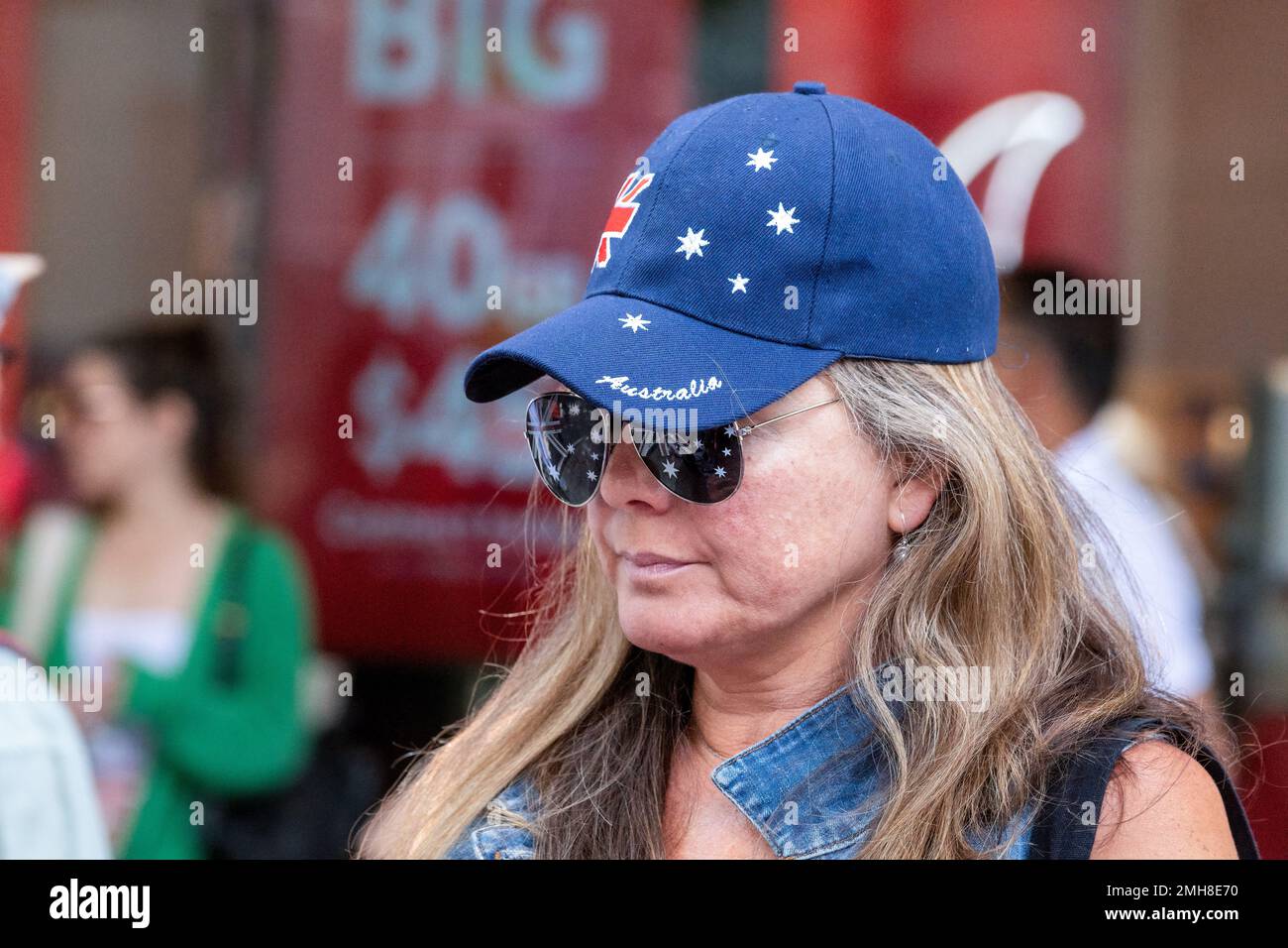 Melbourne, Australia, 26 January, 2023. A woman wearing Australian flag themed glasses and hat on the side lines of the annual Invasion Day protest in Melbourne, organized by Indigenous Australians and their allies, calls for an end to the celebration of Australia Day and for the recognition of Indigenous sovereignty. Credit: Michael Currie/Speed Media/Alamy Live News Stock Photo