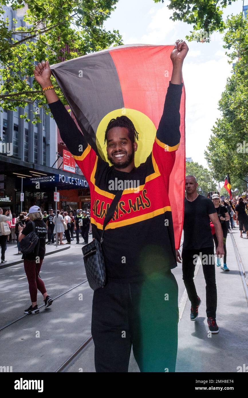 Melbourne, Australia, 26 January, 2023. An indigenous man holds a an aboriginal flag above his head during the annual Invasion Day protest in Melbourne, organized by Indigenous Australians and their allies, calls for an end to the celebration of Australia Day and for the recognition of Indigenous sovereignty. Credit: Michael Currie/Speed Media/Alamy Live News Stock Photo