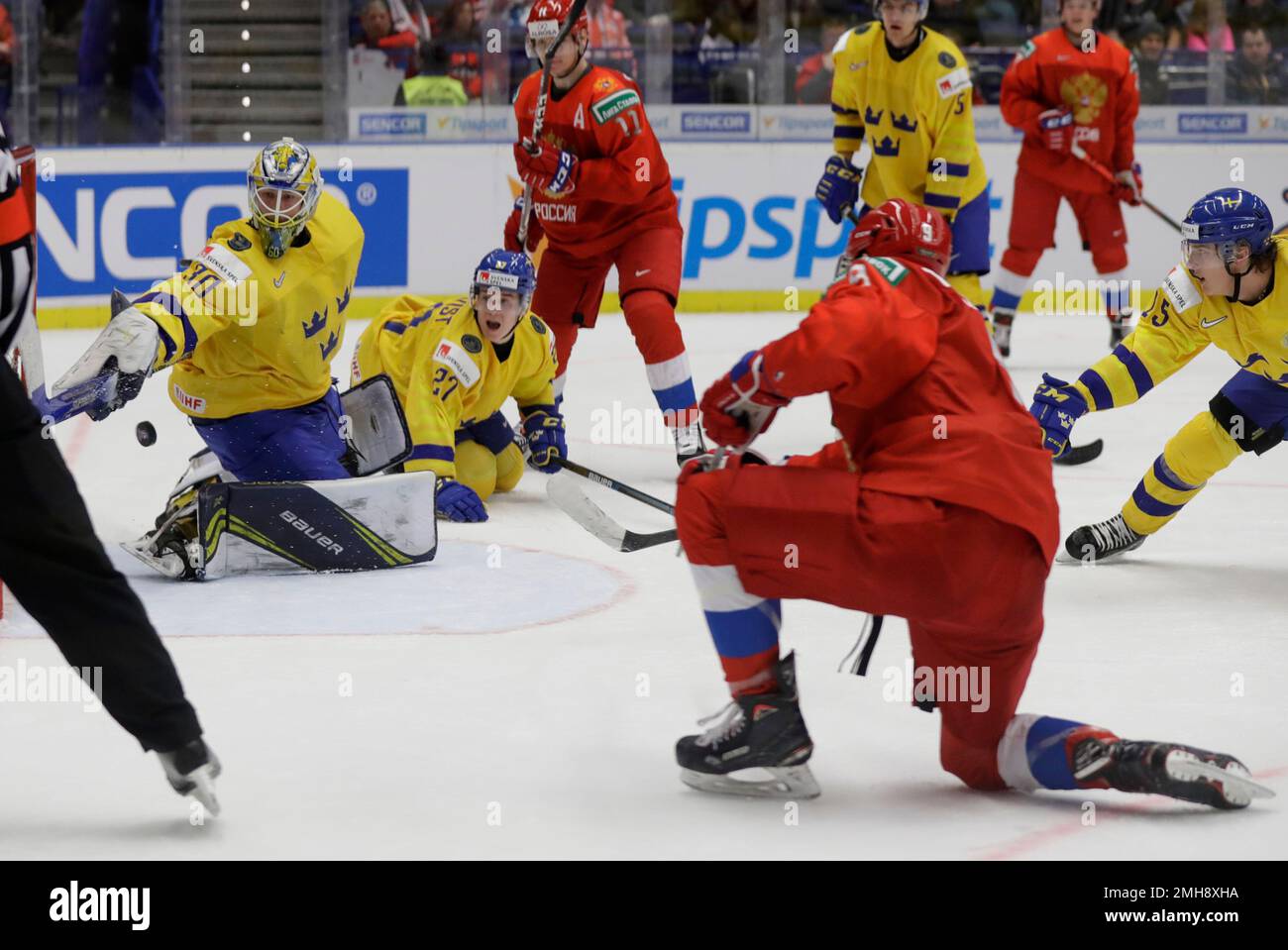 Sweden's goaltender Hugo Alnefelt, left, makes a save against Russia's