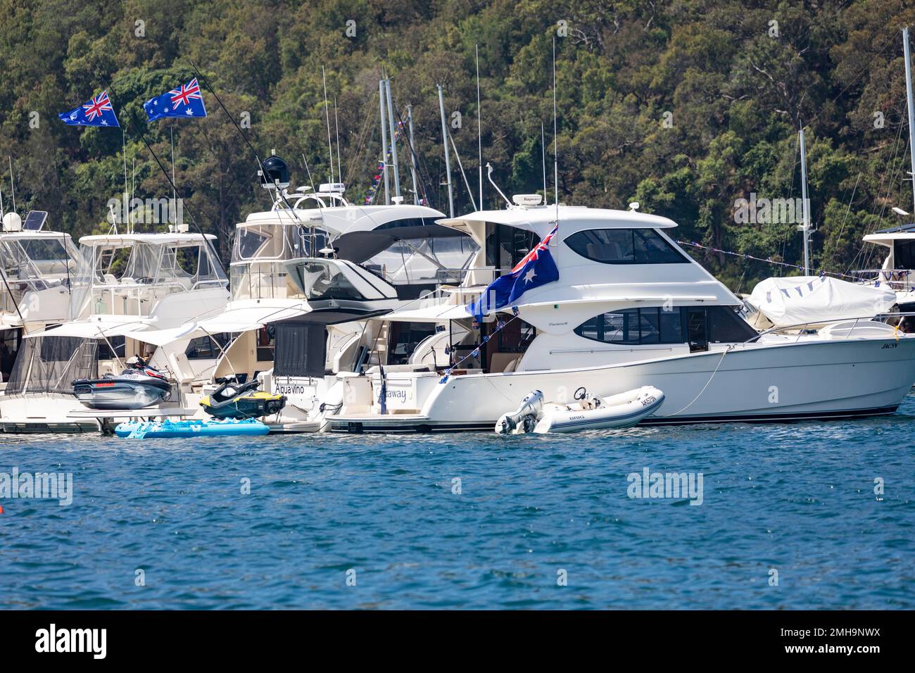 Luxury motor cruiser yachts rafted up on Pittwater Sydney on Australia Day 2023 with australian