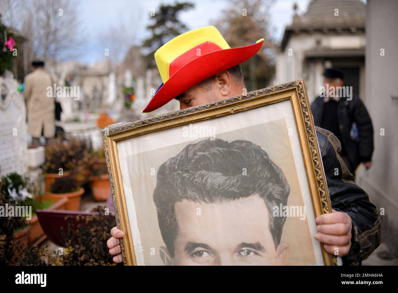 A Man Holds The Official Portrait Of Romanian Communist Dictator ...