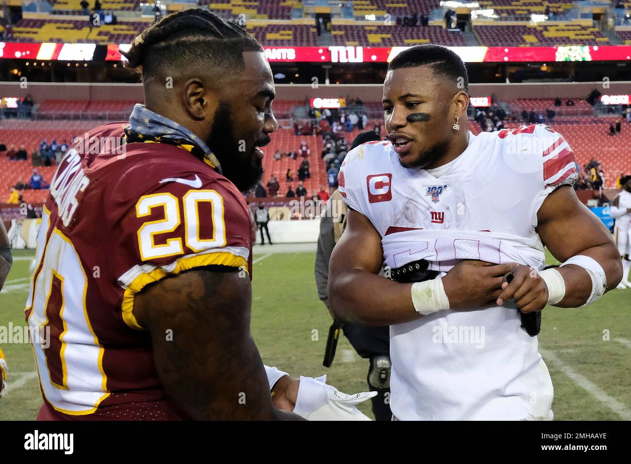 Washington Redskins strong safety Landon Collins (20) and New York Giants  running back Saquon Barkley (26) trade jerseys following an NFL football  game between the New York Giants and the Washington Redskins,