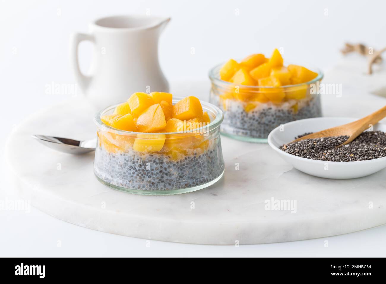 Chia pudding parfaits topped with chopped mango pieces, ready for eating. Stock Photo