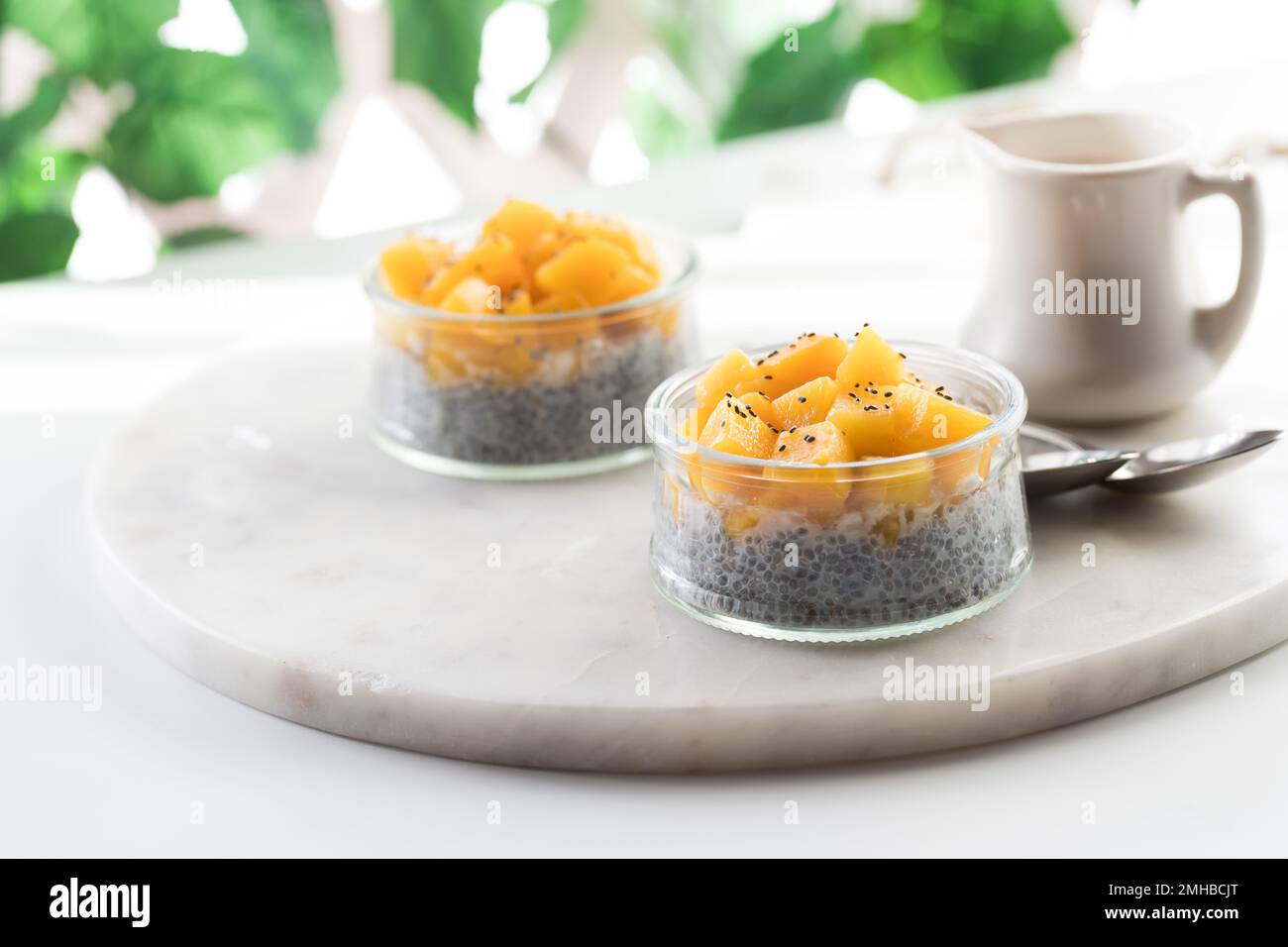 Chia pudding snacks topped with chopped mango against a burry background. Stock Photo