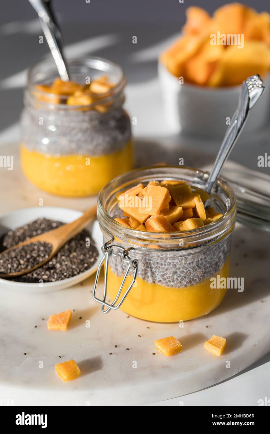 Mango chia pudding snacks in bright sunlight, ready for eating. Stock Photo