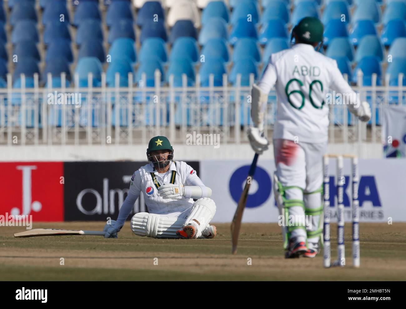 Pakistani batman Azhar Ali, center, looses his balance and looks to