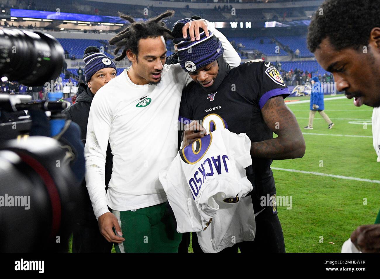 Baltimore Ravens quarterback Lamar Jackson (8) signs a jersey for New York  Jets wide receiver Robby Anderson, left, after an NFL football game,  Thursday, Dec. 12, 2019, in Baltimore. The Ravens won