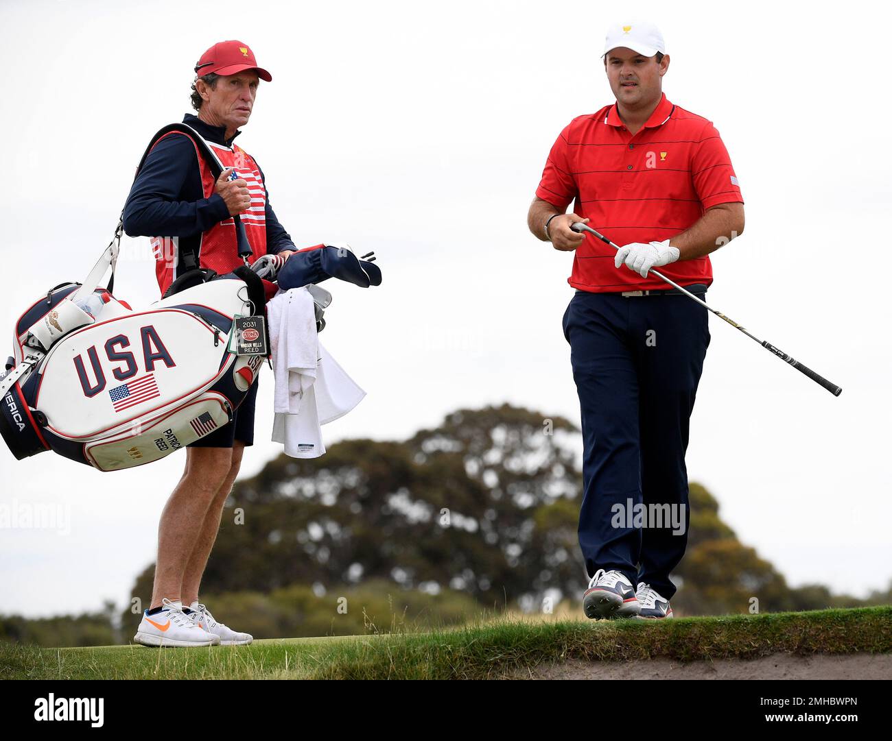 U.S. team player Patrick Reed, right, plays the 6th hole in his singles