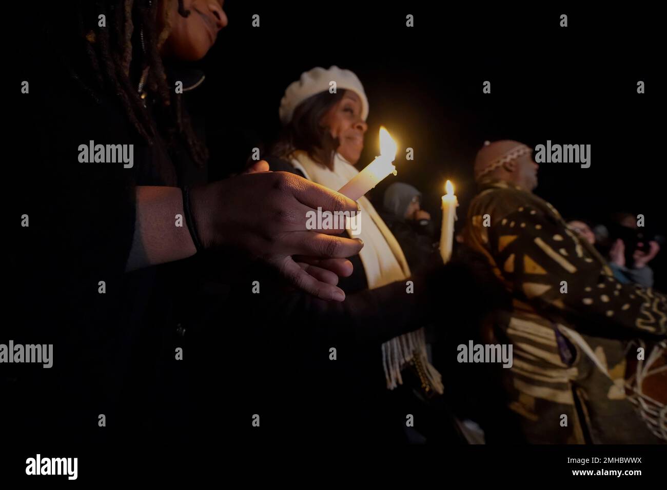 People hold candles at a candlelight vigil for Tyre Nichols, who died