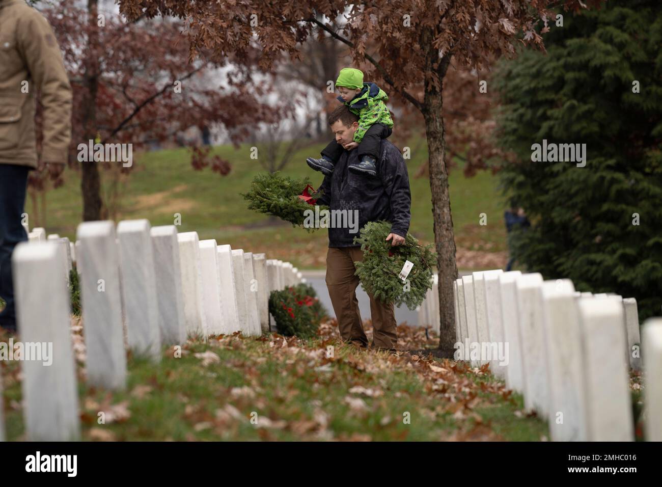 Volunteers lay holiday wreaths at headstones in Arlington National