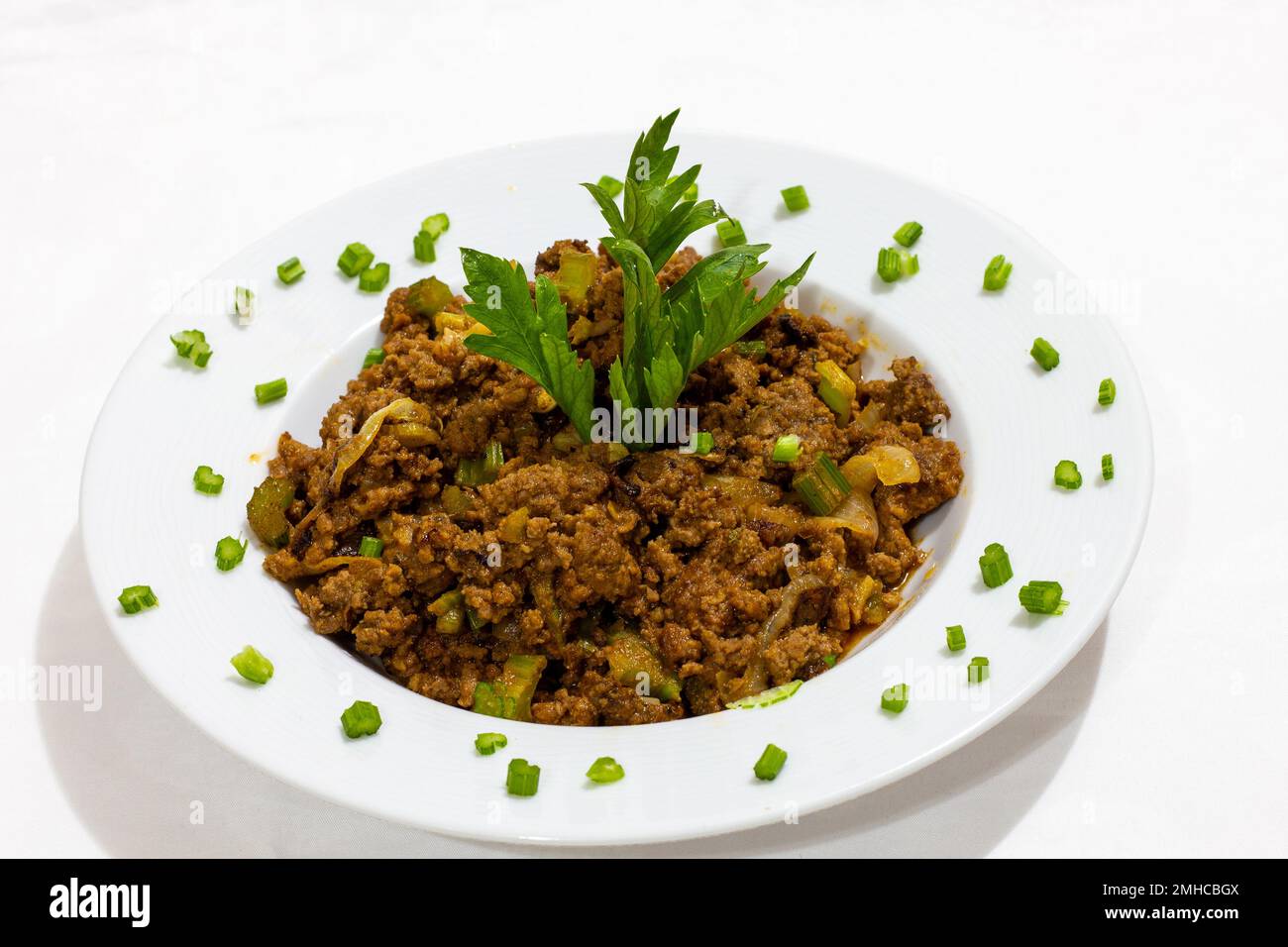 beef hash on a plate on a white background Stock Photo - Alamy