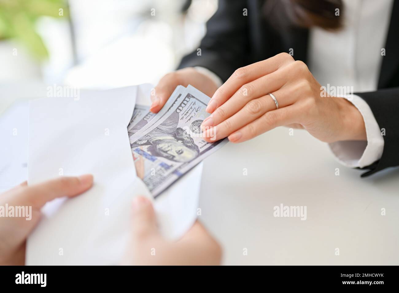 closeup image, A businesswoman sending an envelope with a wad of US