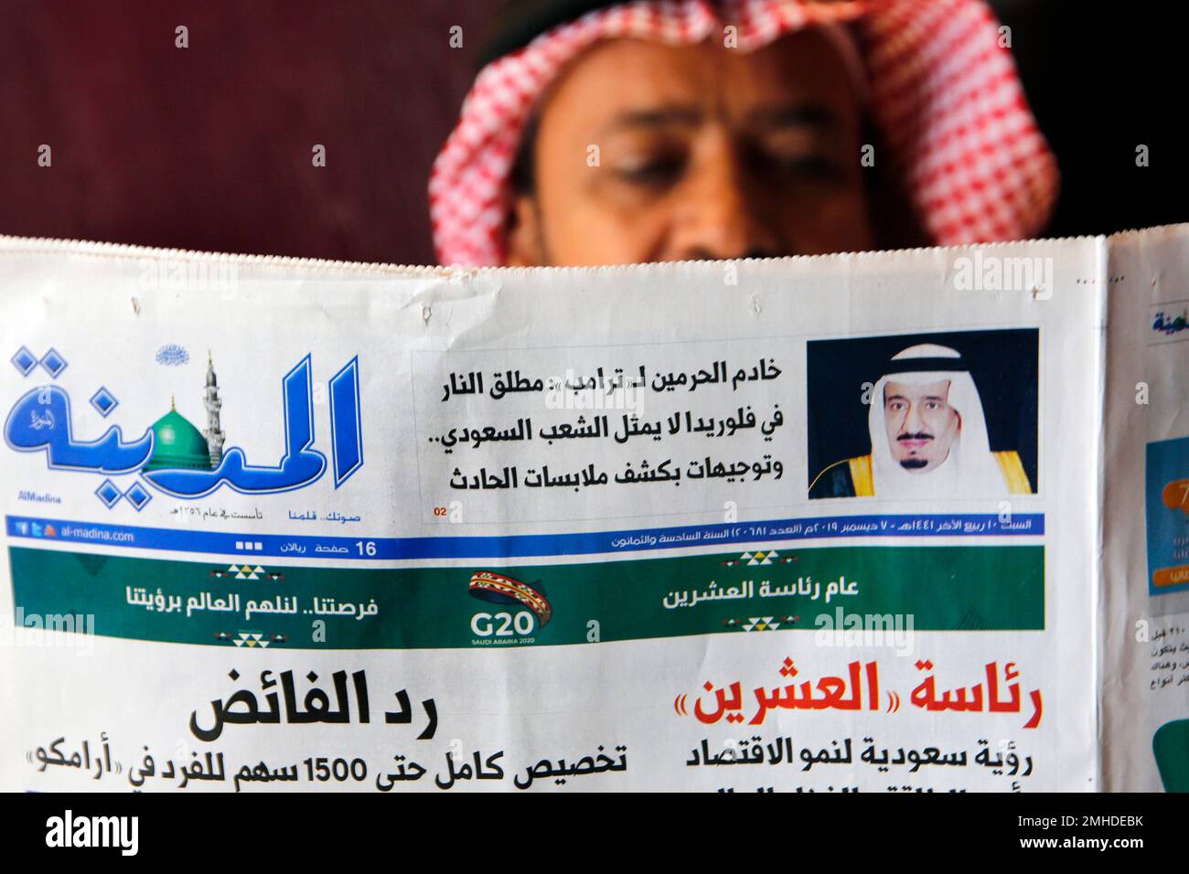 A man reads the daily Al-Madina newspaper fronted by a picture of Saudi ...