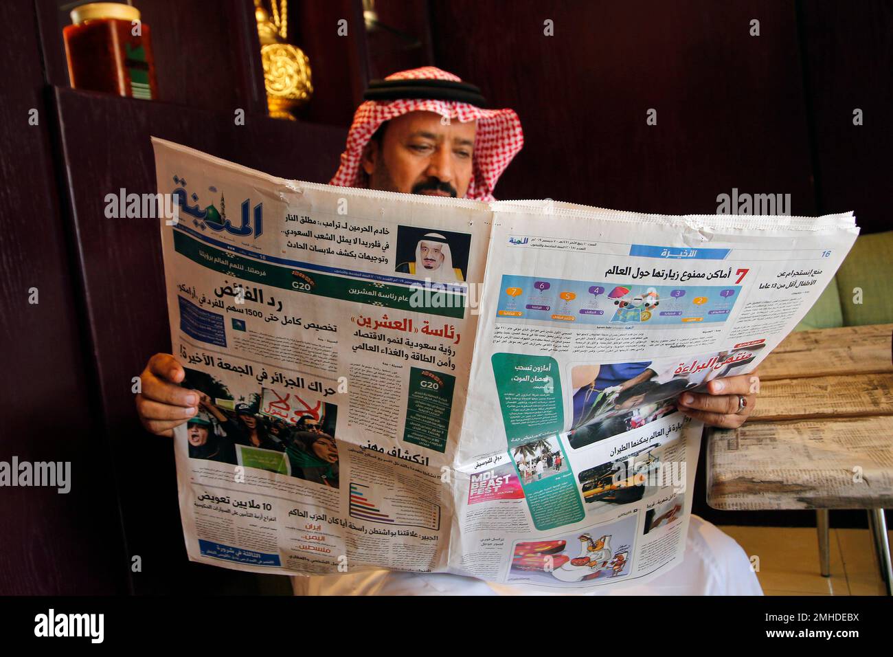 A man reads the daily Al-Madina newspaper fronted by a picture of Saudi ...