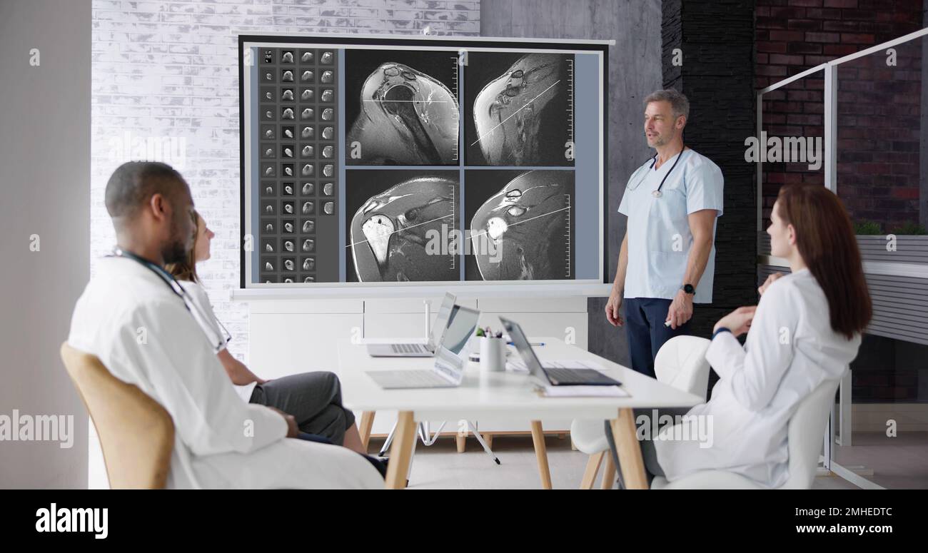 Physician Doctors Looking At Shoulder MRT Scan Stock Photo