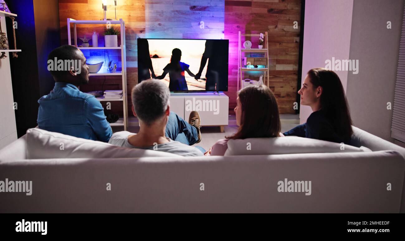 Couples Watching TV At Night. Television Screen Stock Photo