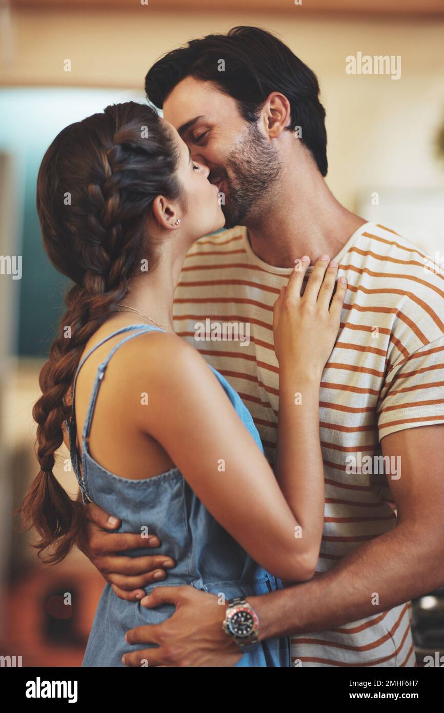 I can describe how much I love you. an affectionate young couple kissing in their kitchen at home. Stock Photo