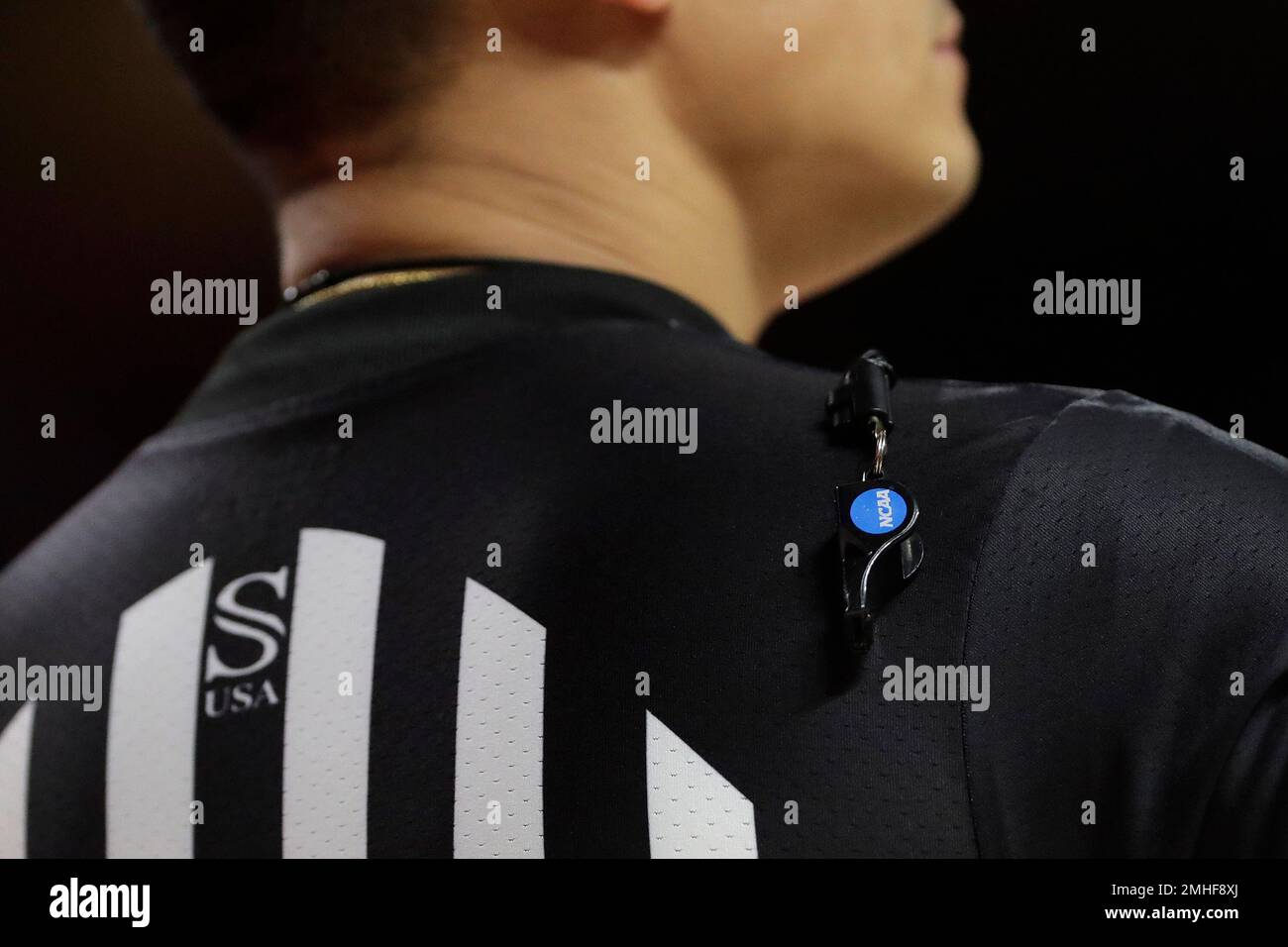 A referee's whistle hangs over his shoulder during the first half of an