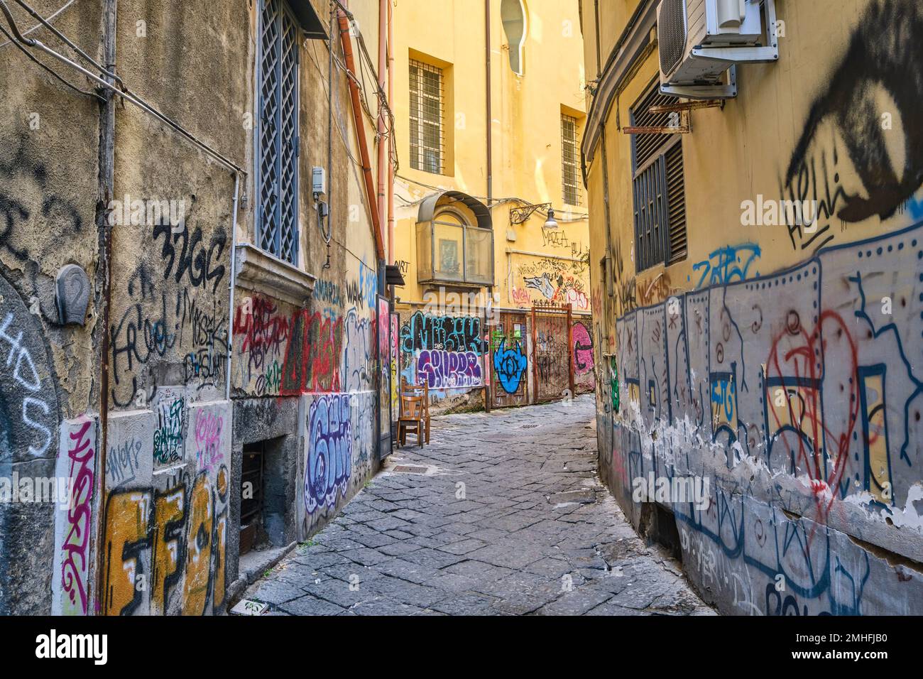 A small, curving alley in the Centro Historico neighborhood, walls covered. An example of graffiti in Naples, Napoli, Italy, Italia. Stock Photo