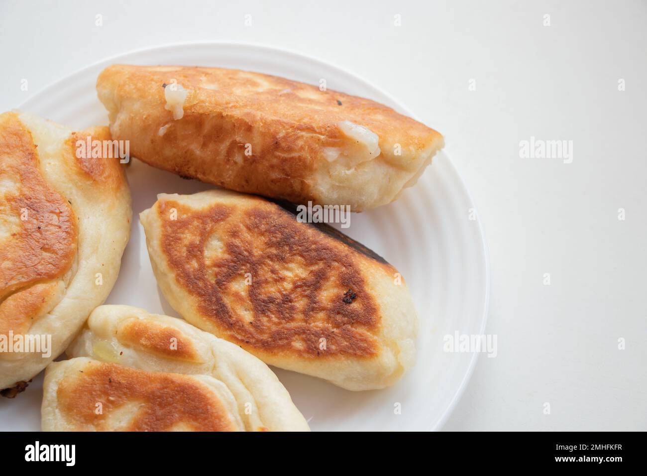 fried pasties on a plate on a white background Stock Photo