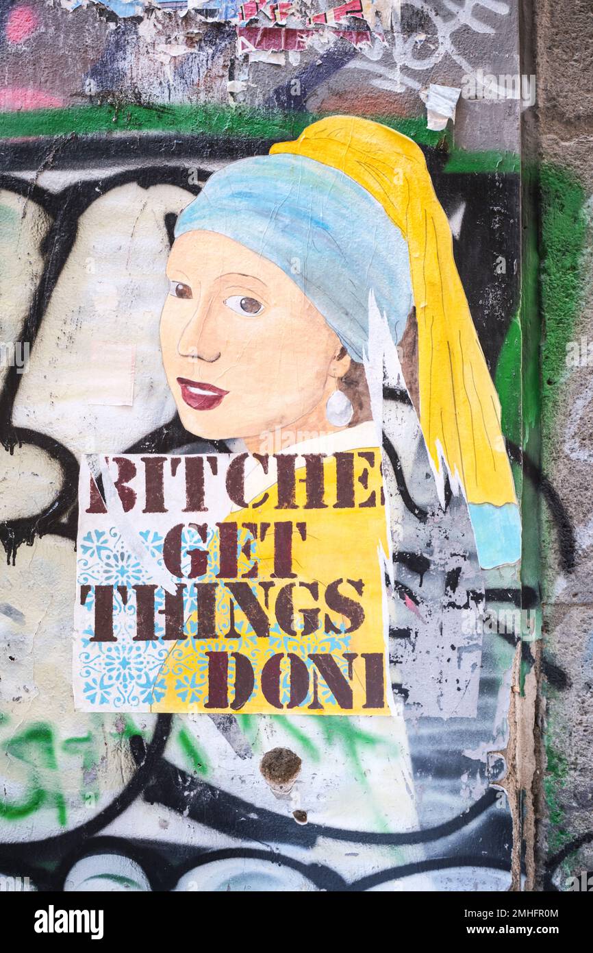 A fake version of Johannes Vermeer's Girl With A Pearl Earing. The slogan, Bitches Get Things Done has been stenciled on it. An example of graffiti in Stock Photo