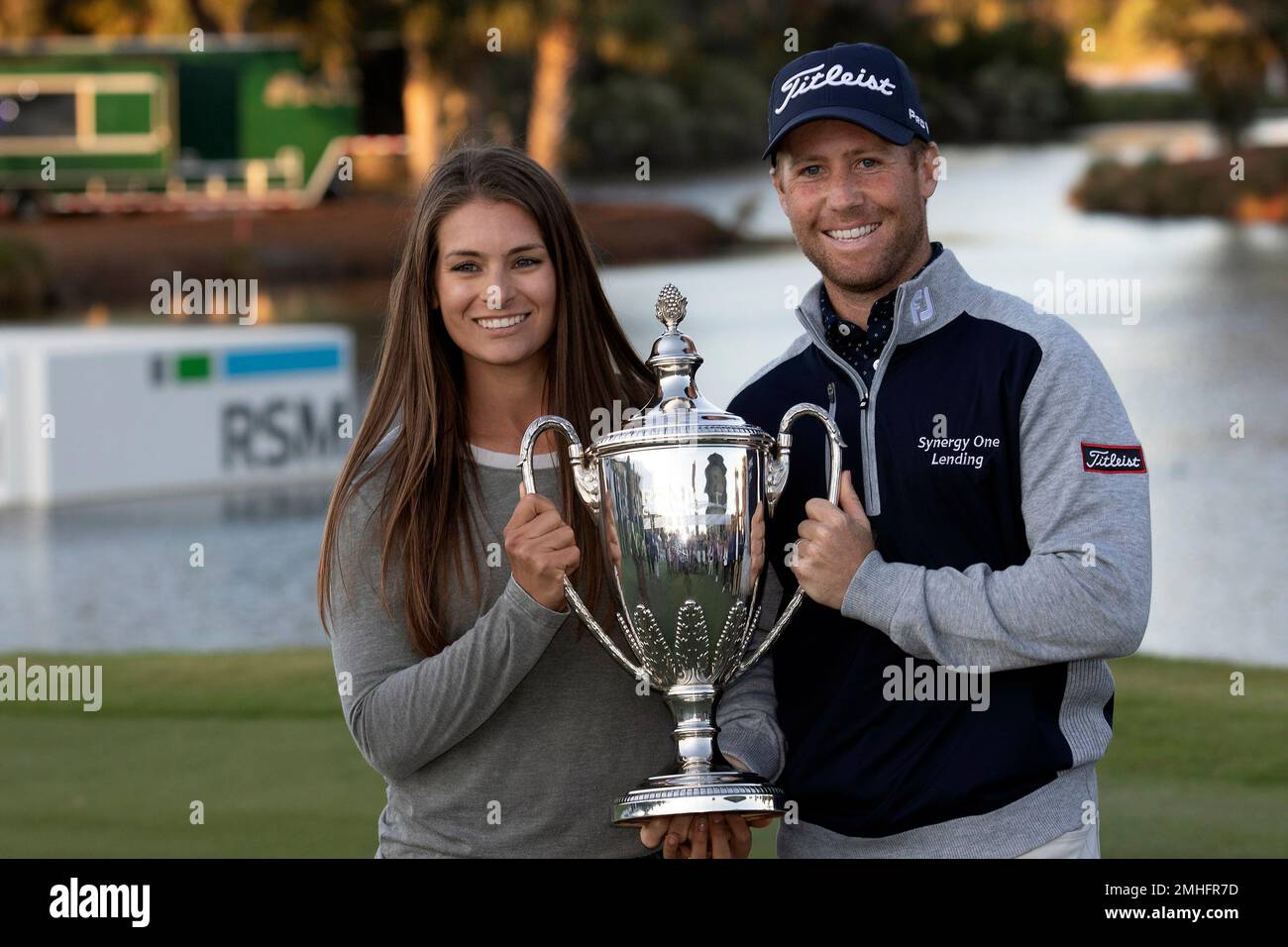 Tyler Duncan and his wife Maria Duncan hold the winning trophy after a second hole playoff during the final round of the RSM Classic golf tournament in St