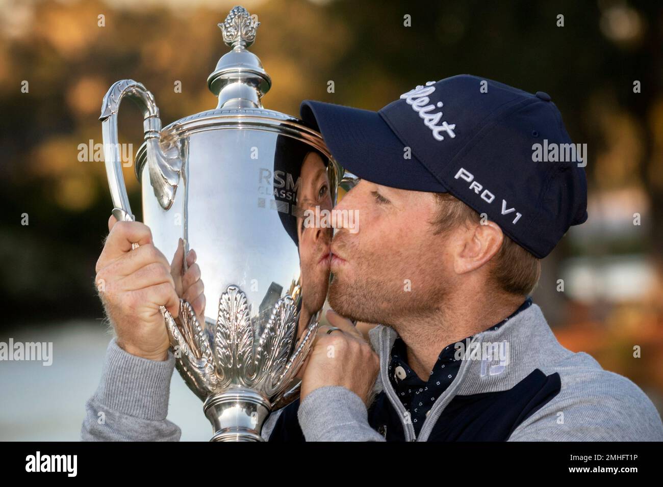 Tyler Duncan kisses the trophy after a winning a second hole playoff against Webb Simpson during the final round of the RSM Classic golf tournament in St
