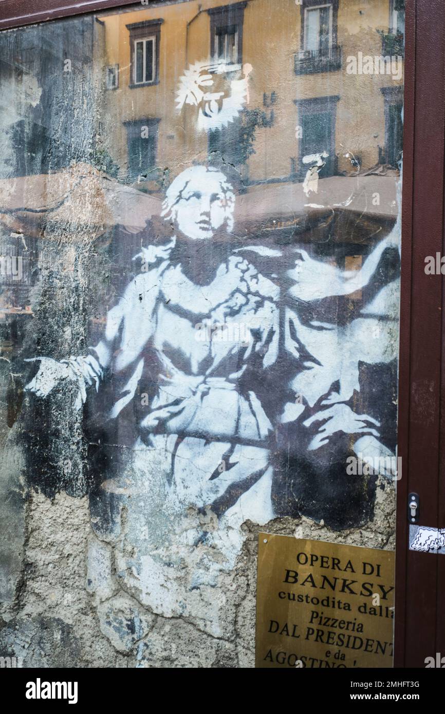 A Banksy, Madonna with a Pistol, now protected under glass. An example of graffiti in Naples, Napoli, Italy, Italia. Stock Photo