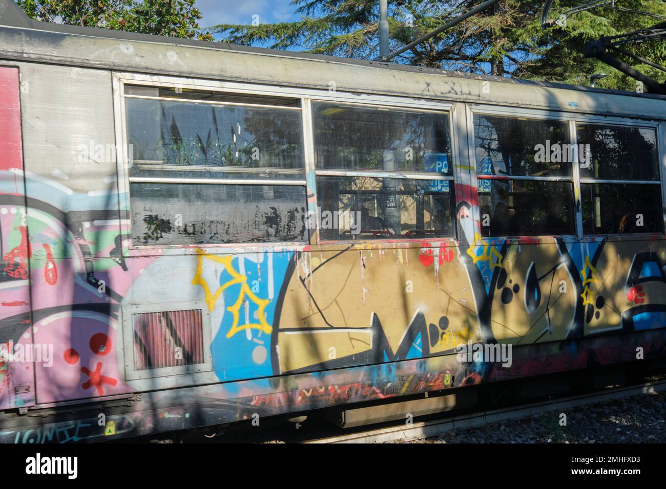 A grafitti covered commuter train pulling into a rail station near Pompeii. An example of graffiti in Naples, Napoli, Italy, Italia. Stock Photo