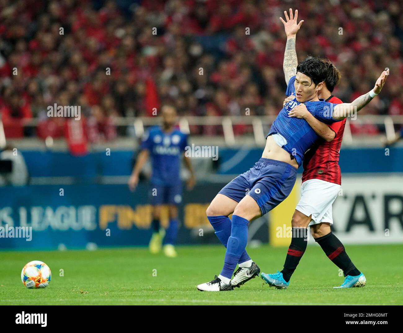 Al Hilal's Ali Al Bulayhi, right, fights for the ball with Urawa