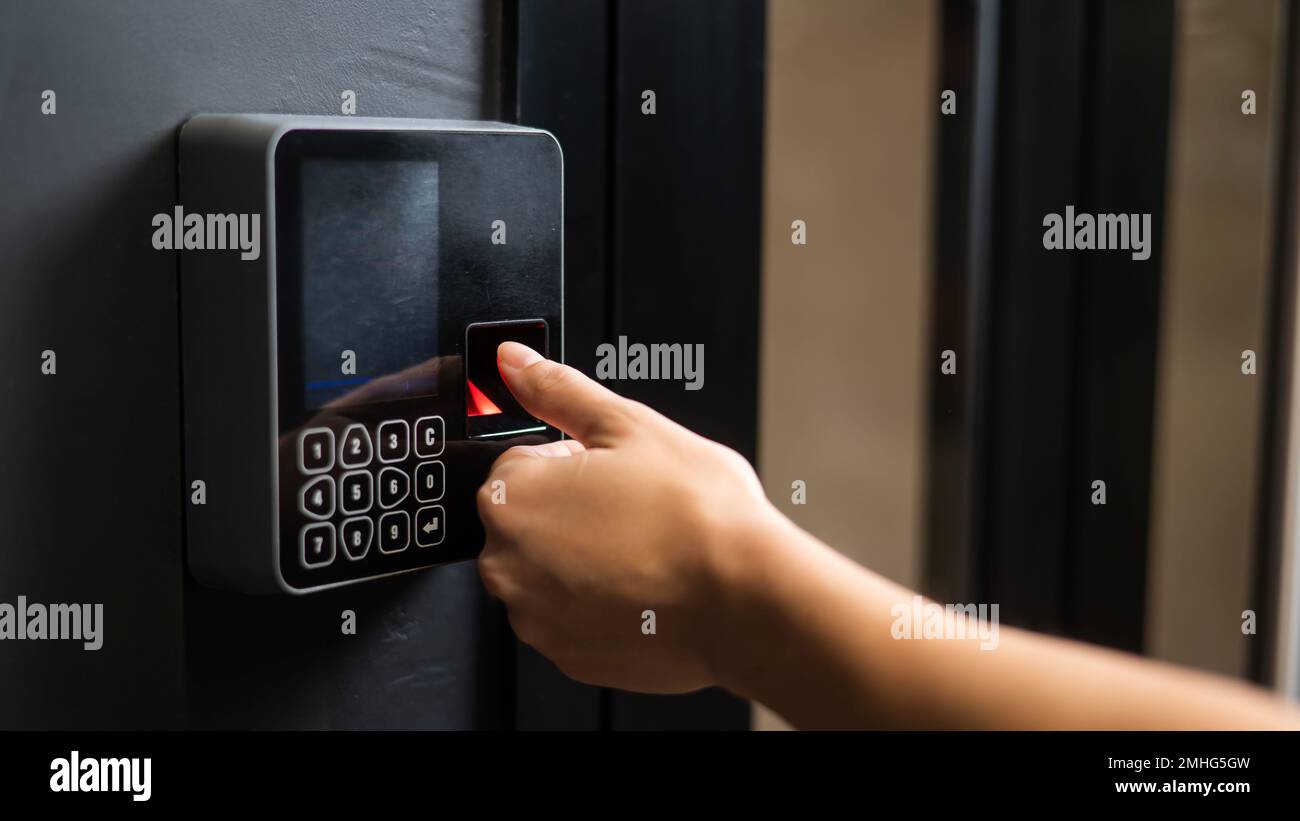 A woman opens the door with her fingerprint. Modern keyless entry lock.  Stock Photo