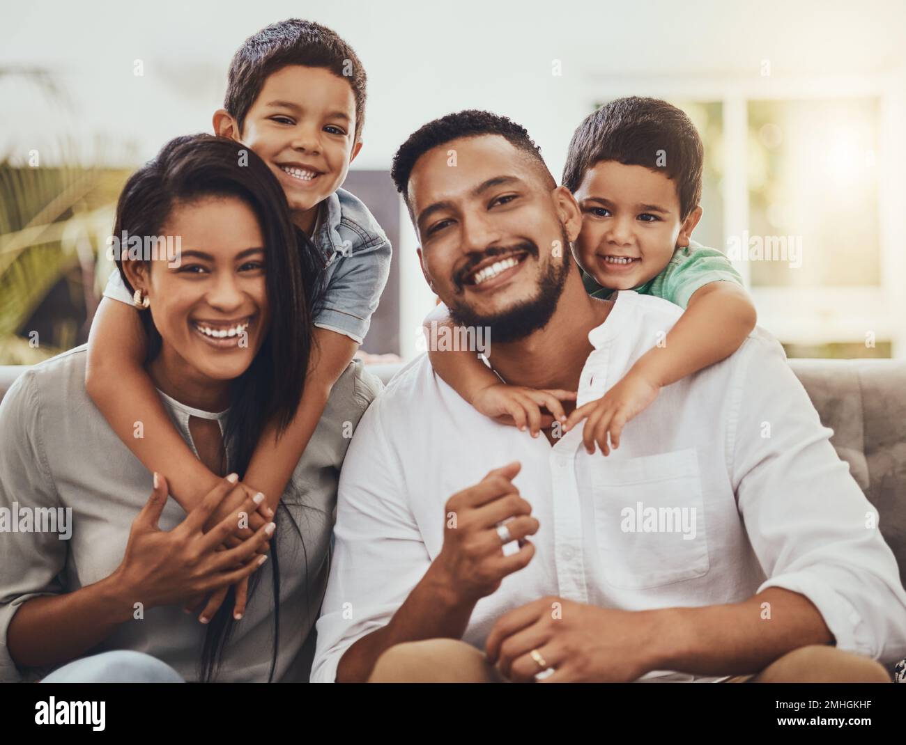 Mother, father and children hug for family portrait with smile relaxing ...