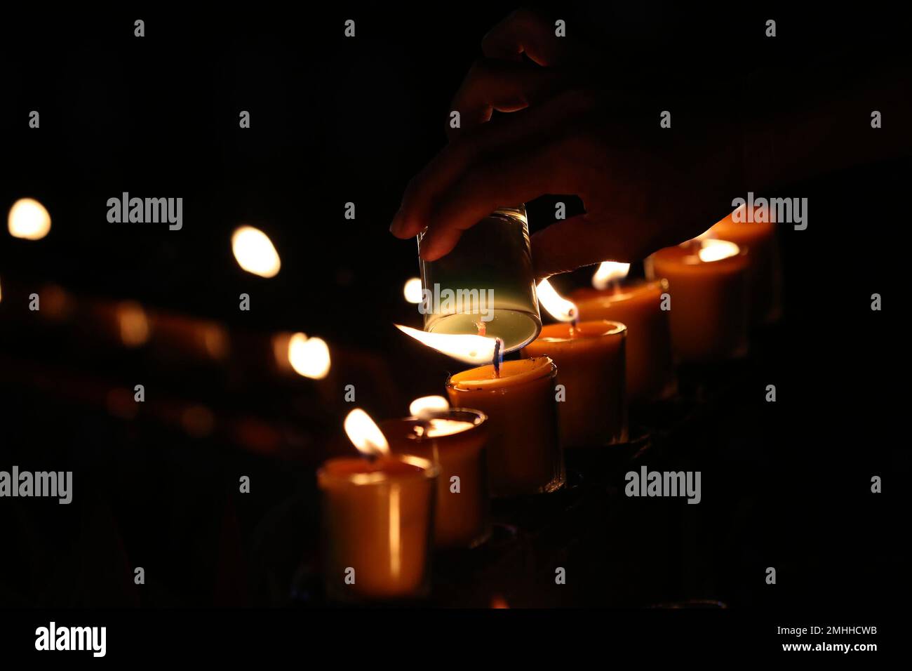 In this Friday, Oct. 18, 2019, photo, Catholic devotees light candles ...