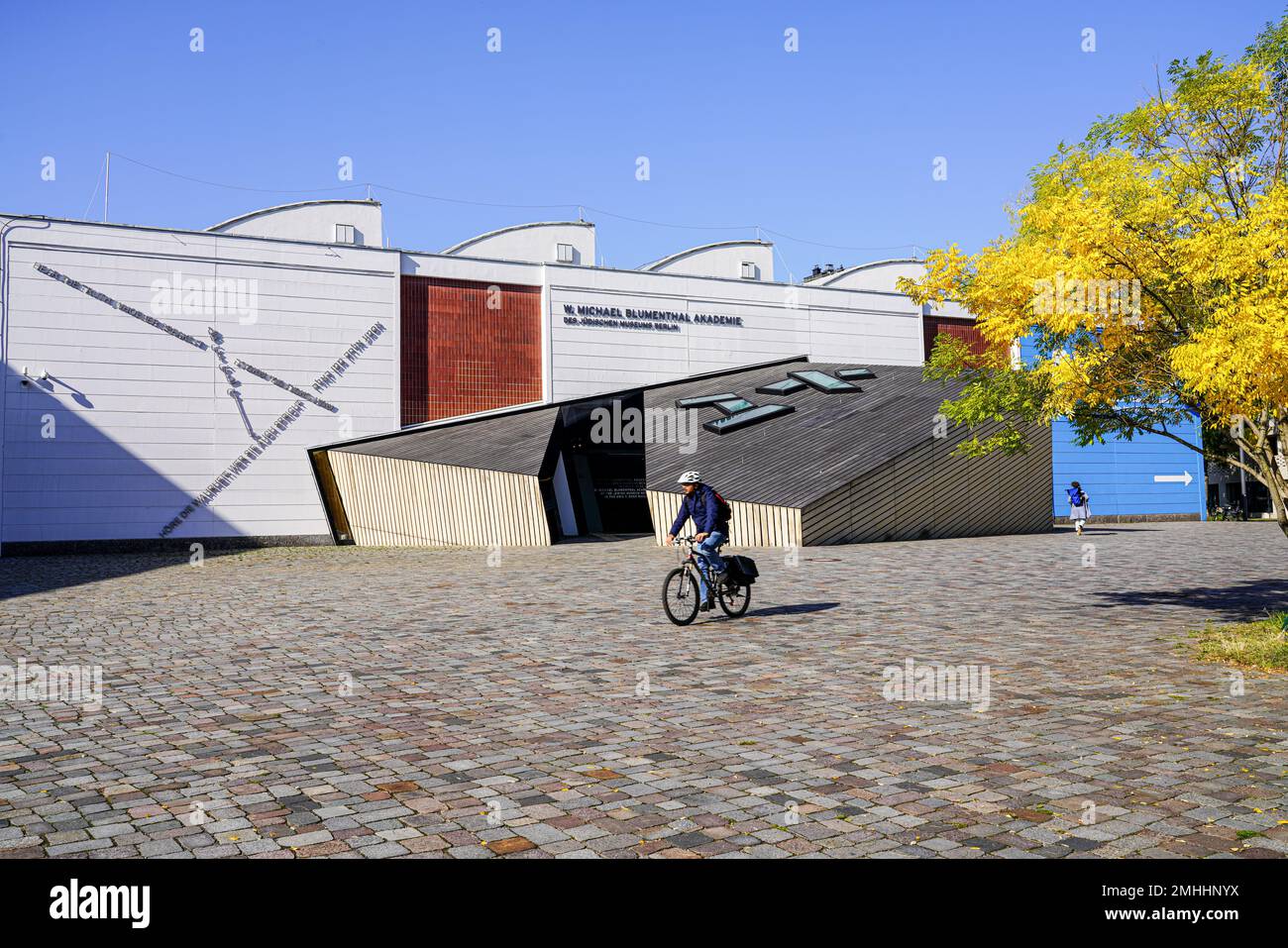 A cyclist in front of the W. Michael Blumenthal Academy of the Jewish Museum in Berlin was rebuilt according to a design by Daniel Libeskind. Stock Photo