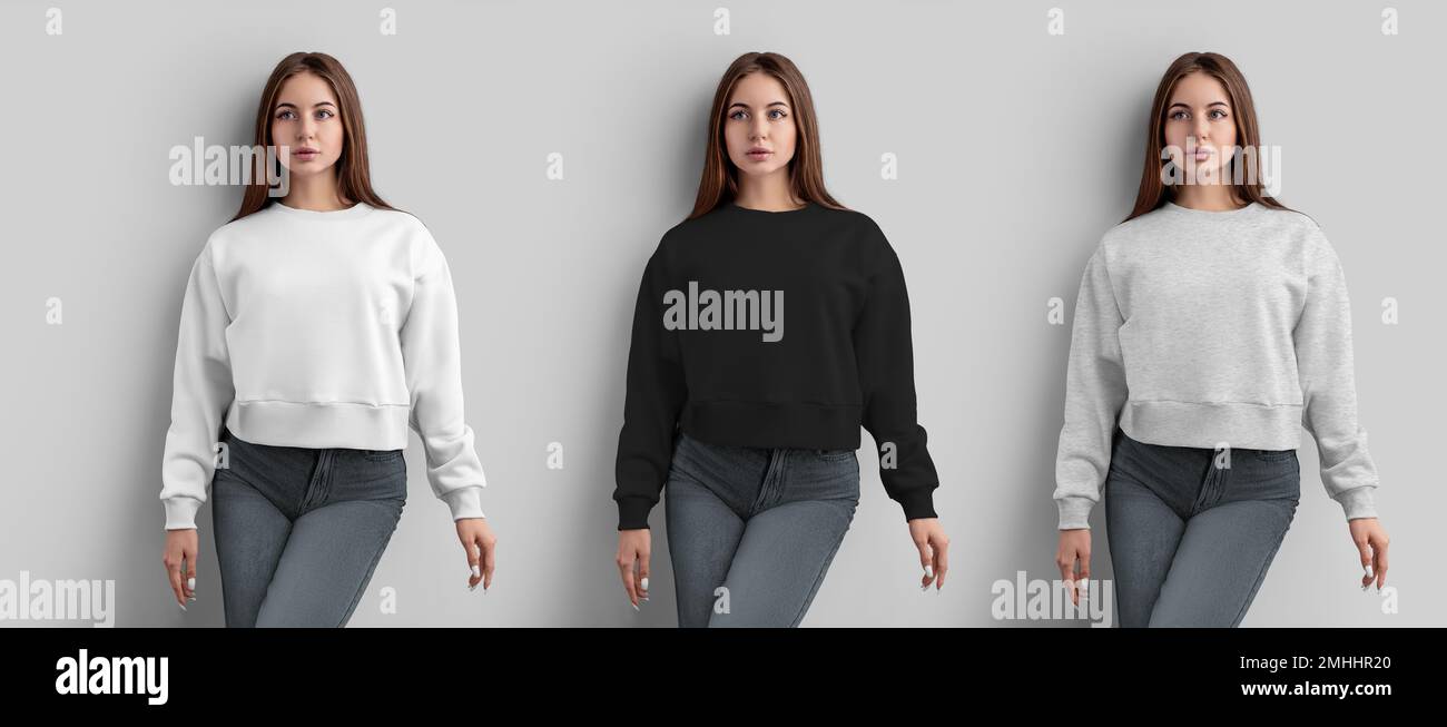 Mockup of a white, black, heather crop sweatshirt on a girl in gray jeans, female longsleeve, front view, isolated on a wall background. Set of women' Stock Photo