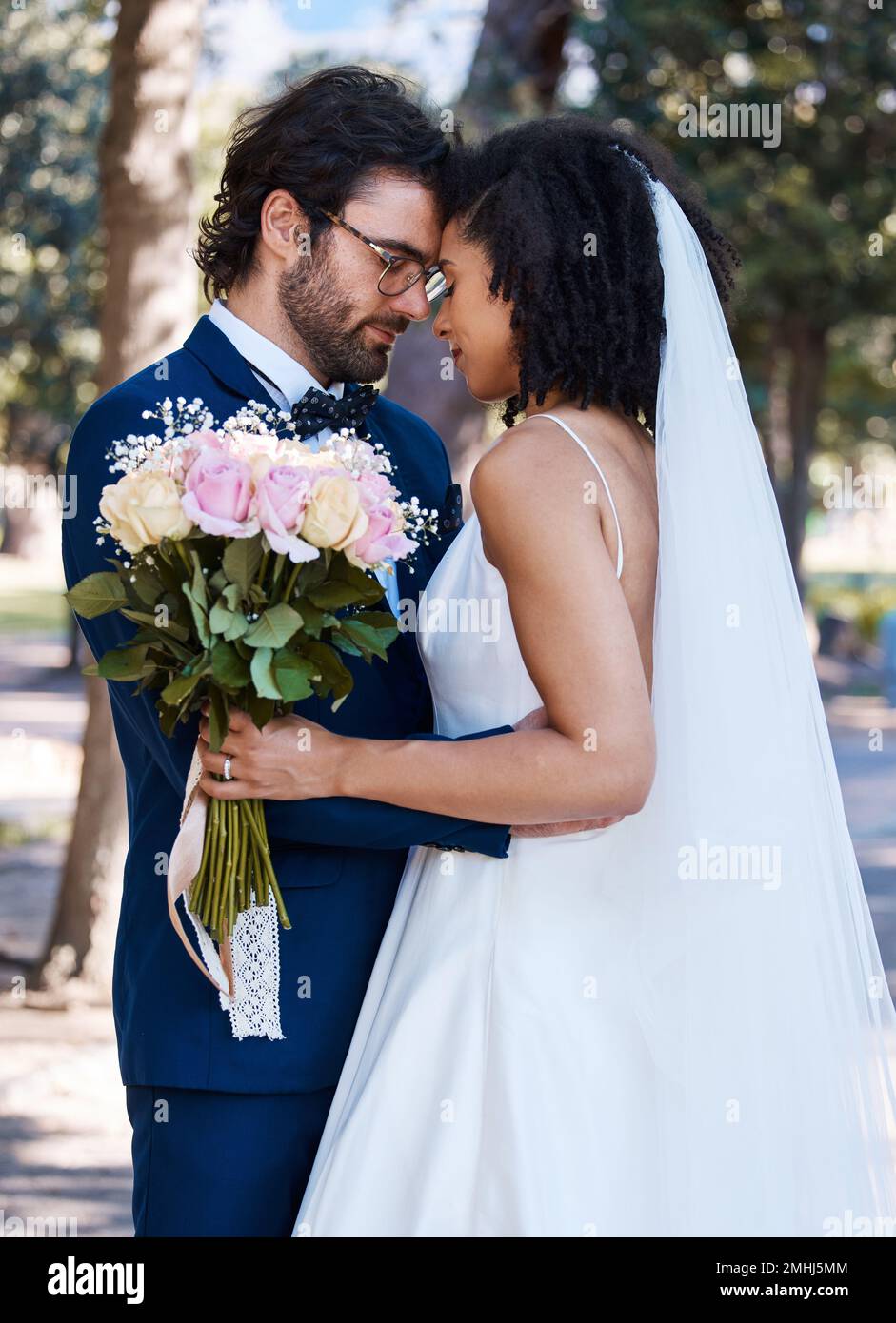 Wedding, couple and marriage outdoor with commitment, trust and love with bride and groom in park. Life partner, married man and black woman with rose Stock Photo
