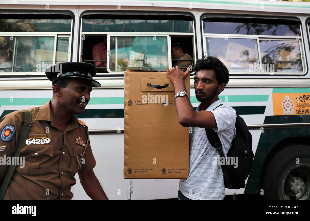 A Sri Lankan polling worker carries ballot papers and boxes to a bus