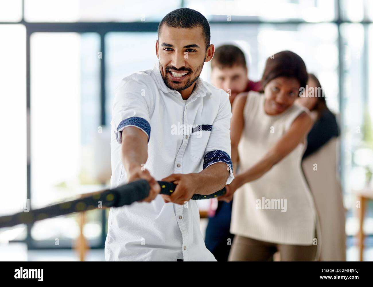 Pull. a group of young designers pulling on a rope during tug of war ...