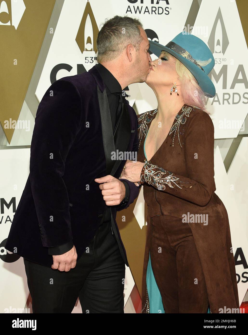 Buddy Quaid, left, and Tanya Tucker kiss at the 53rd annual CMA Awards