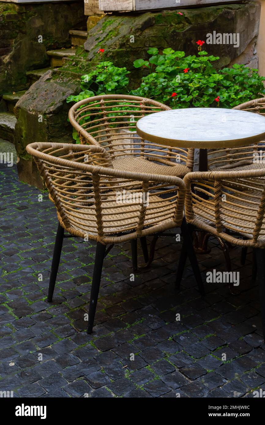Empty wet wooden table and chairs on terrace of outdoor cafeteria