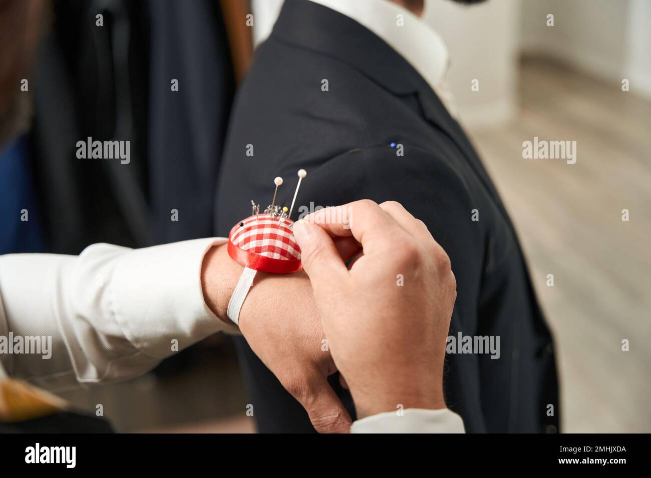 Experienced tailor conducting fitting session with client Stock Photo