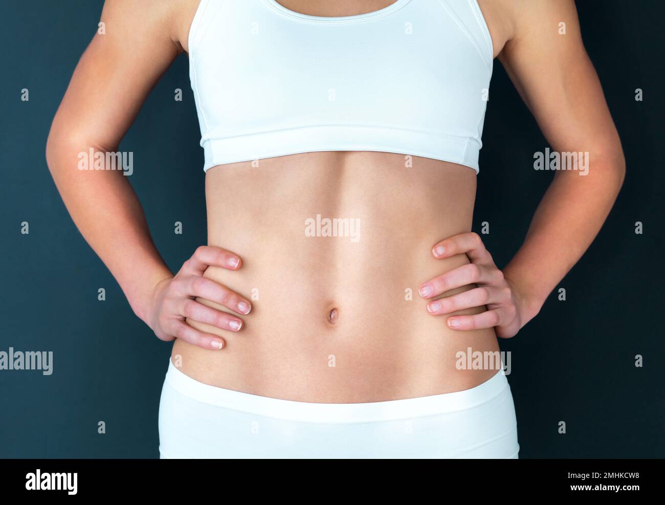 Athletic woman examines her beautiful muscular female belly