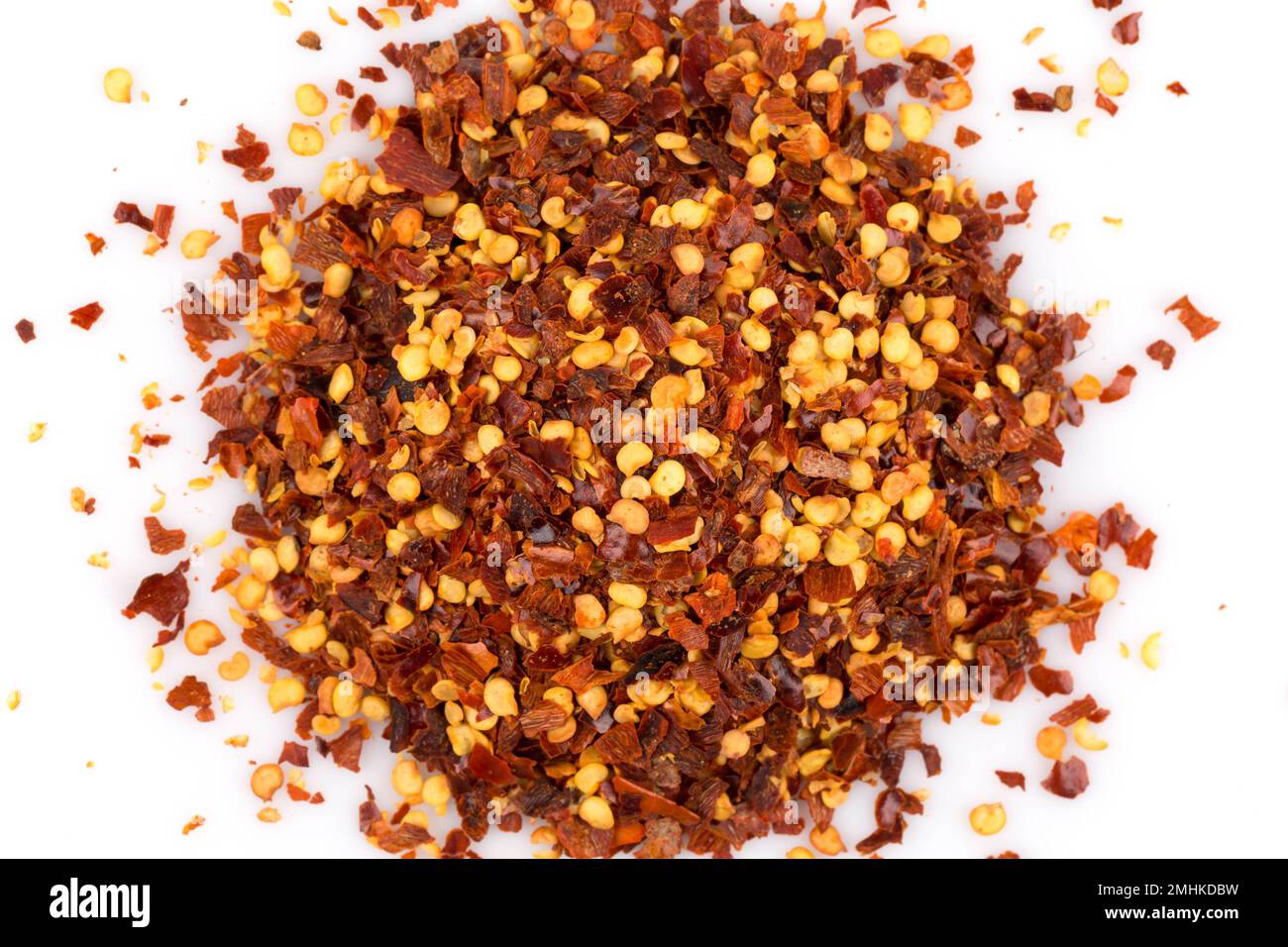 The pile of a crushed red pepper, dried chili flakes and seeds isolated